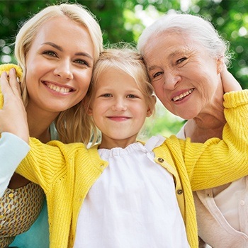 Mother daughter and granddaughter smiling outside