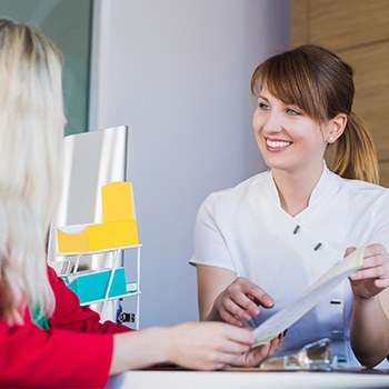 Team member showing patient dental insurance forms