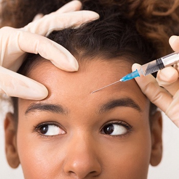 a person receiving a BOTOX injection in their forehead