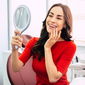 Woman looking at metal free dental restoration in mirror