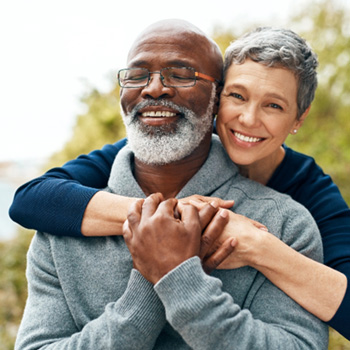Chesterton patient and partner smiling with new replacement teeth