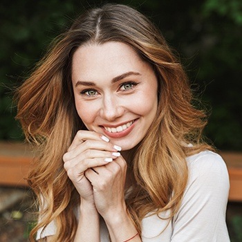 Woman with beautiful smile after dental implant placement