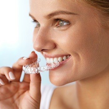 Woman placing Invisalign tray