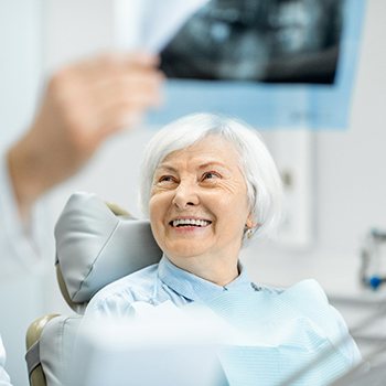 An older woman smiling at her dental appointment.