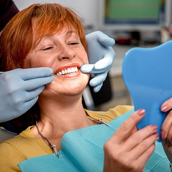 An older woman examining her new smile.