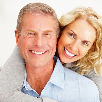 An older couple smiling and hugging.