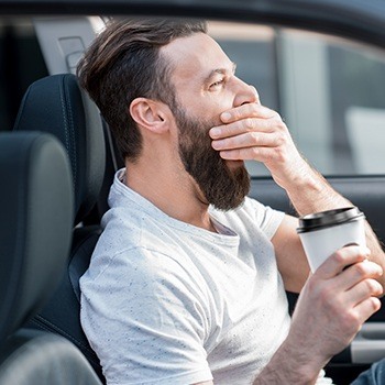 Yawning man in car needs sleep apnea therapy