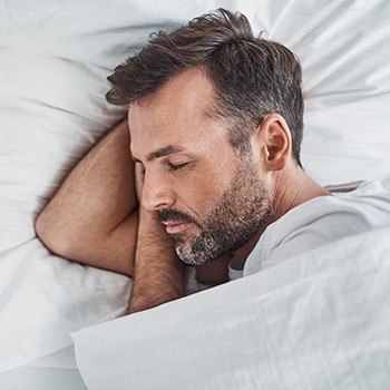 Man sleeping soundly after sleep apnea therapy