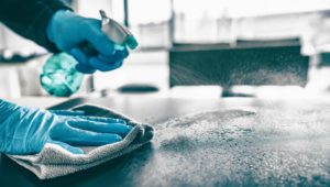 dental staff sanitizing a surface