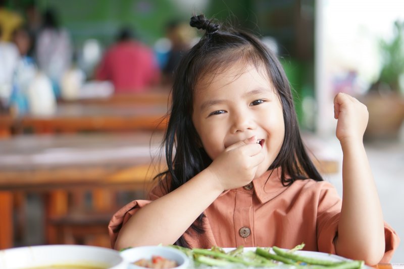 young child eating school lunch