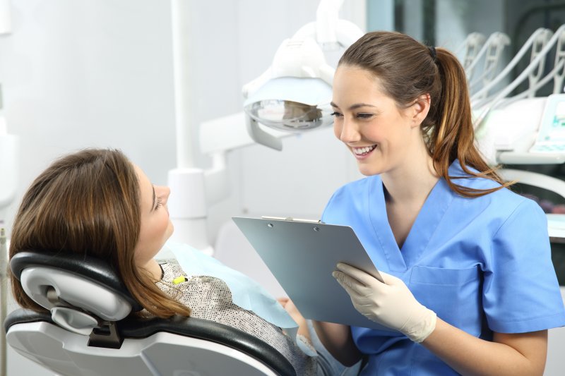 ental assistant smiling while talking to patient