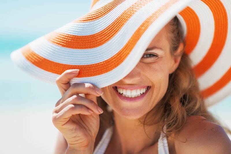 Woman smiles on beach.