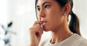 Woman at risk of harming her teeth by biting fingernails